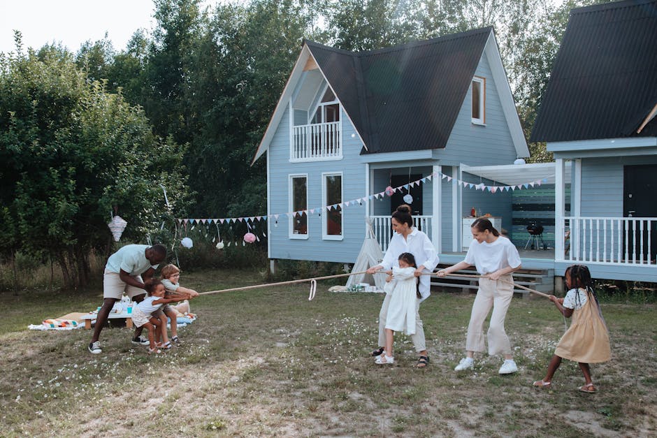 happy family playing tug of war outdoors in summer