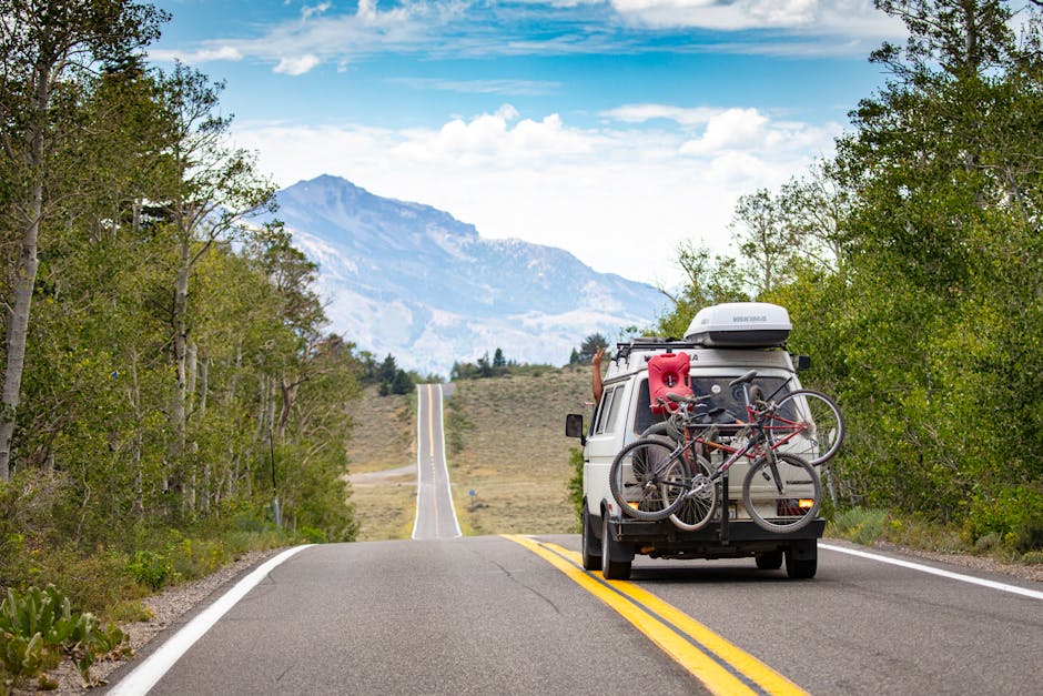 camper van driving through a stunning mountain landscape on a summer road trip