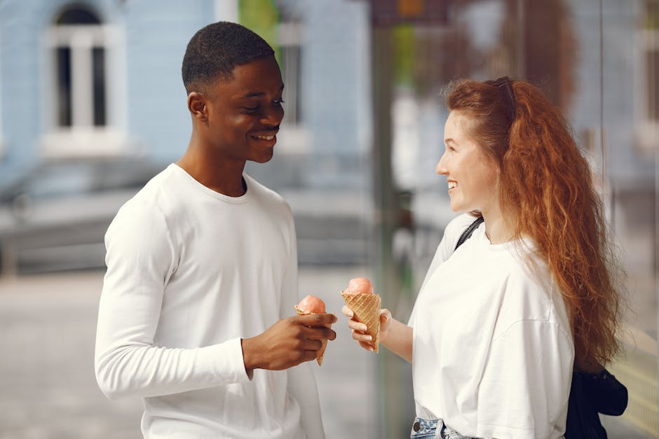 smiling couple enjoying ice cream cones together outdoors in summer