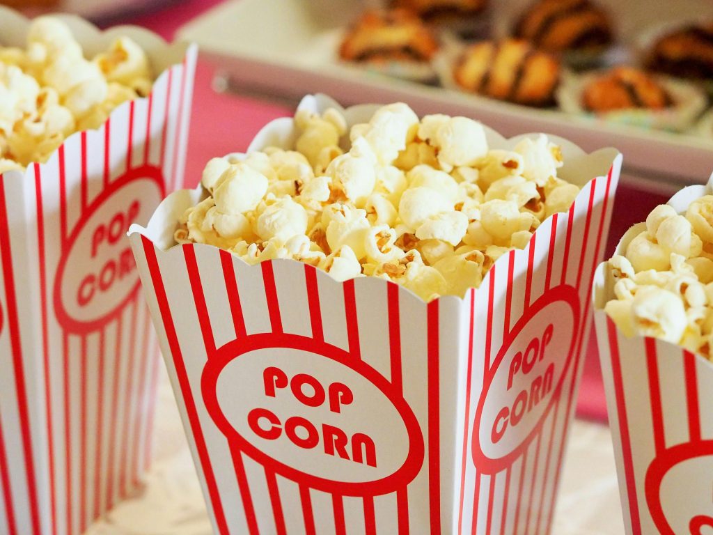 Classic red and white striped popcorn boxes filled with buttery popcorn for movie night