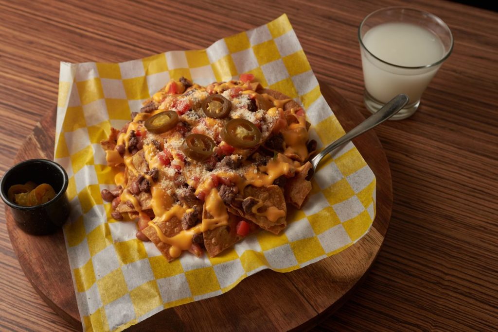 Cheesy nachos topped with jalapenos for a build-your-own watch party snack bar