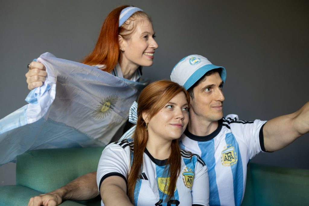 Fans in team jerseys cheering while watching a World Cup soccer match indoors