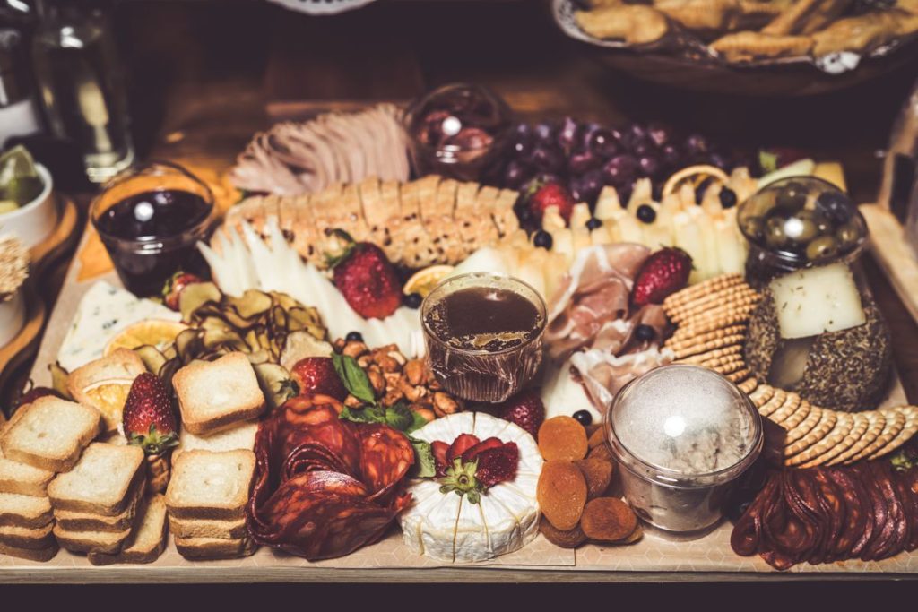 Loaded charcuterie board with meats, cheeses, crackers, and fruit for a watch party
