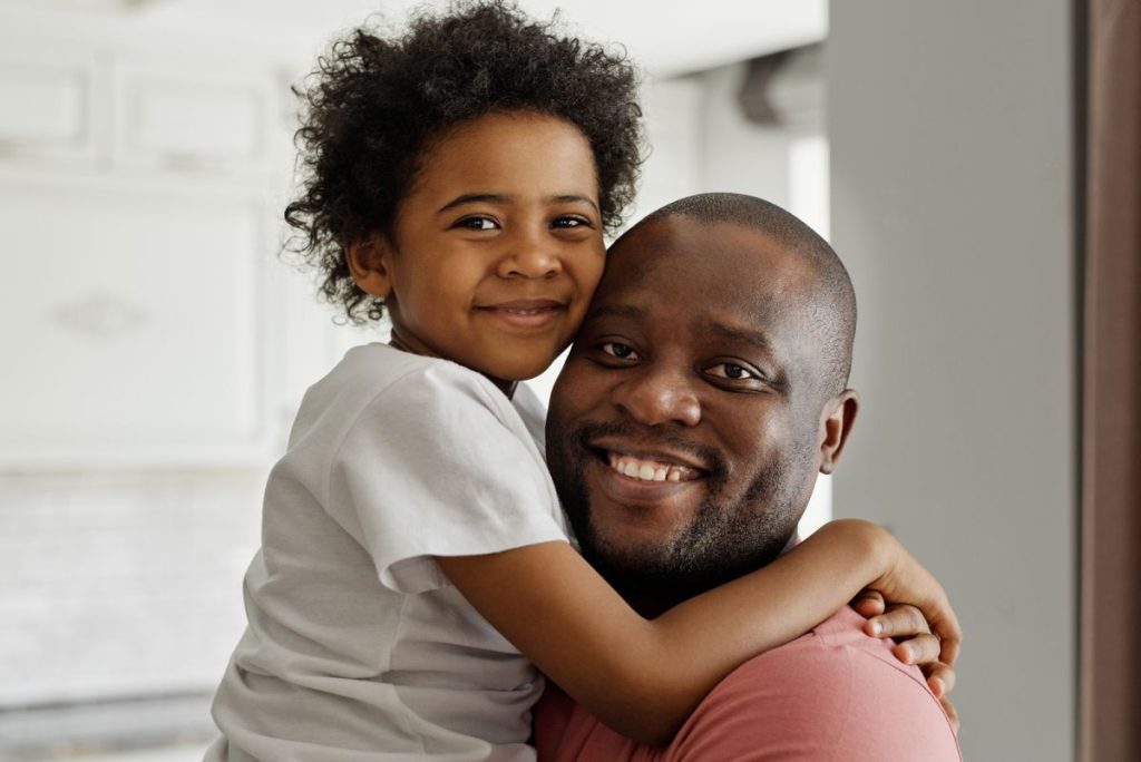 A smiling father hugging his happy child on Father's Day