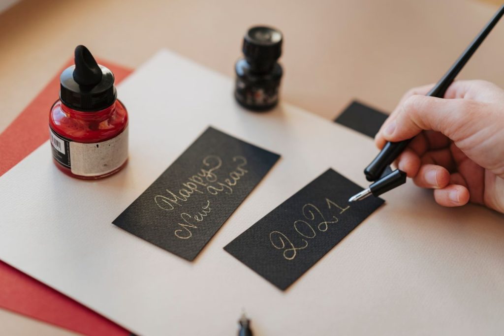 Hands writing a heartfelt message inside a Father's Day card